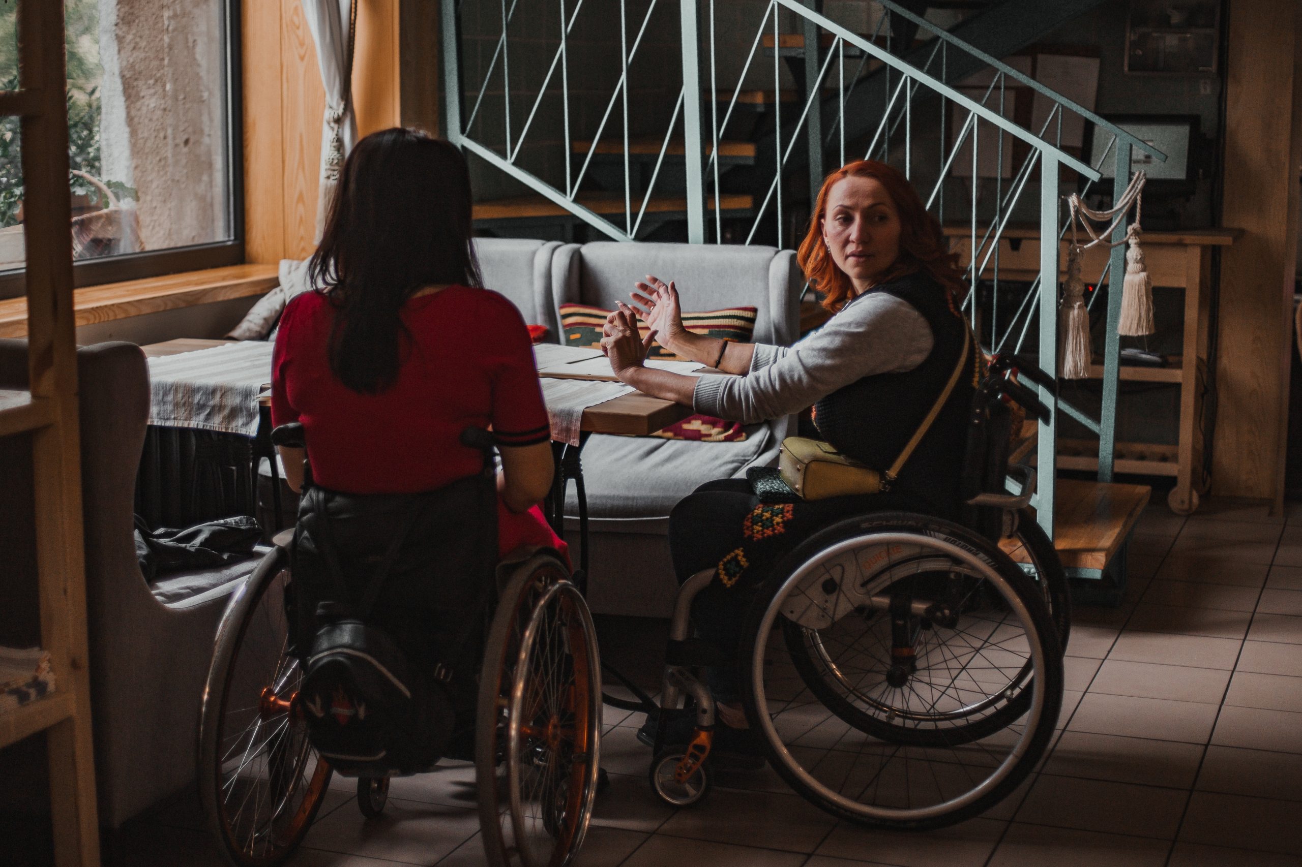 girlfriends-on-wheelchairs-in-a-cafe-opposite-the-2026-01-06-08-54-26-utc