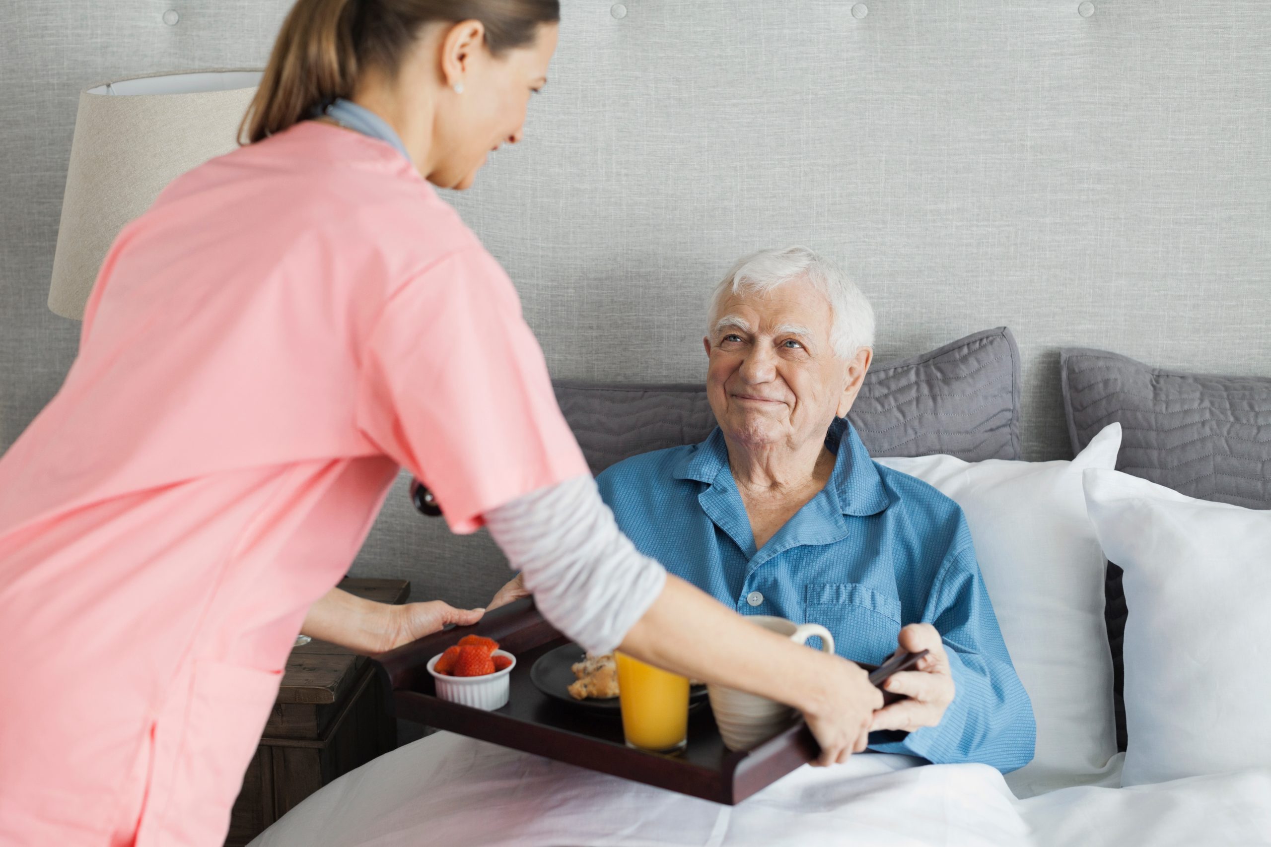 home-care-nurse-serving-breakfast-to-senior-man-2026-01-11-08-40-45-utc